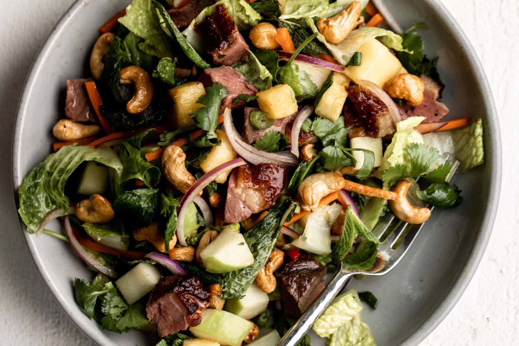Thai Crispy Duck Salad with romaine lettuce, herbs and cashews.