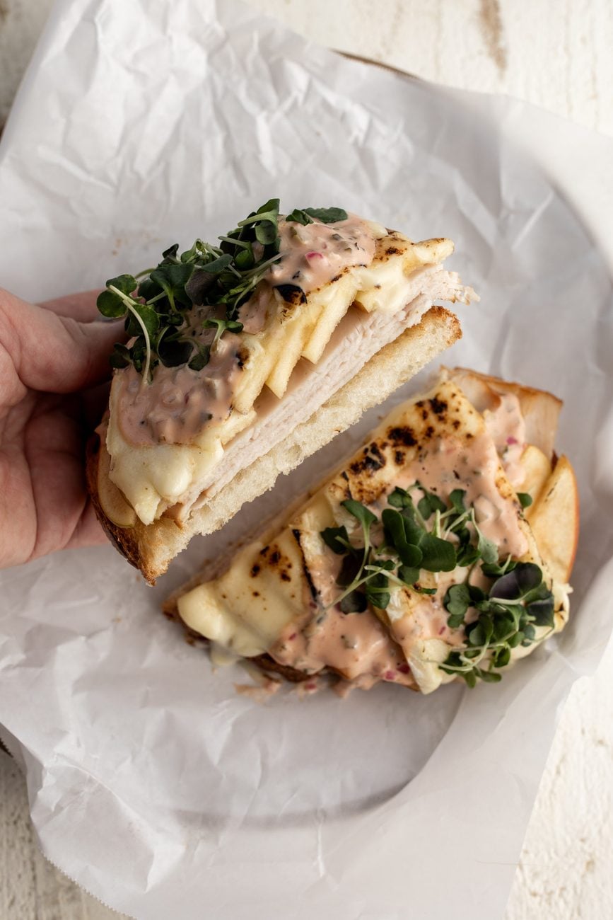 turkey apple and brie open-face sandwich with micro-greens.