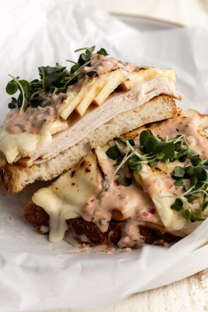 turkey apple and brie open-face sandwich with microgreens.