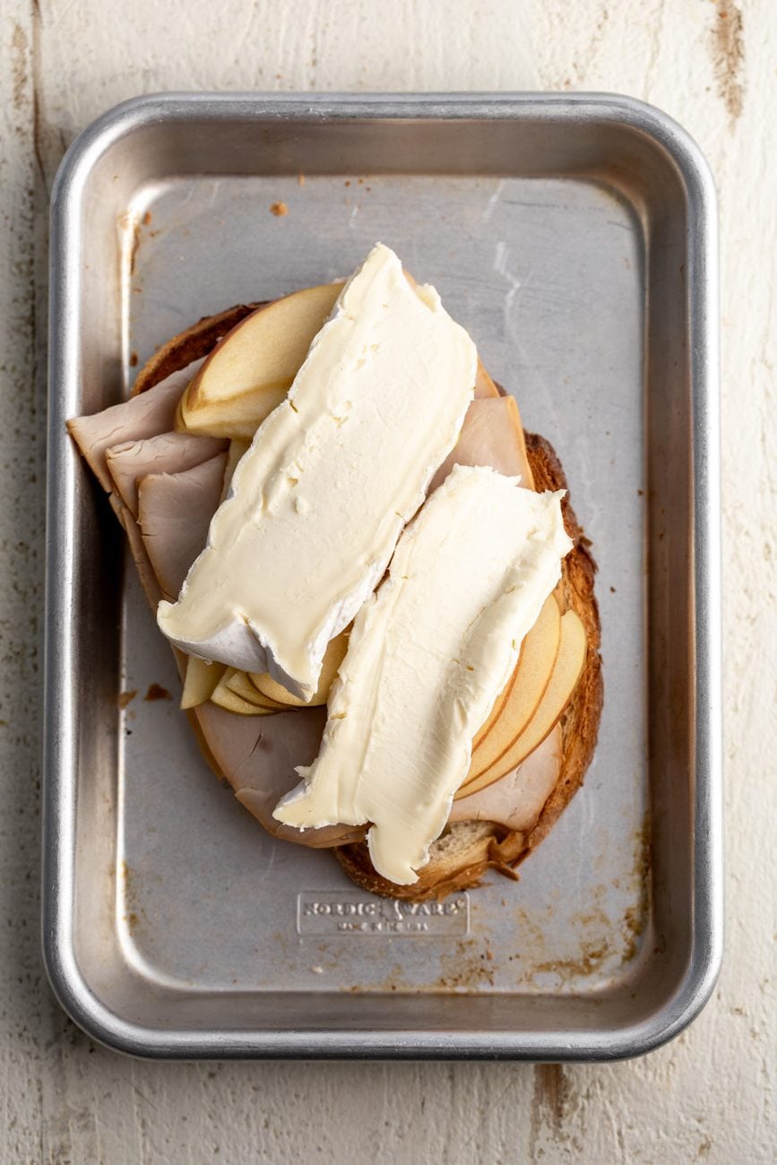sliced bread topped with deli turkey, sliced apples and brie.