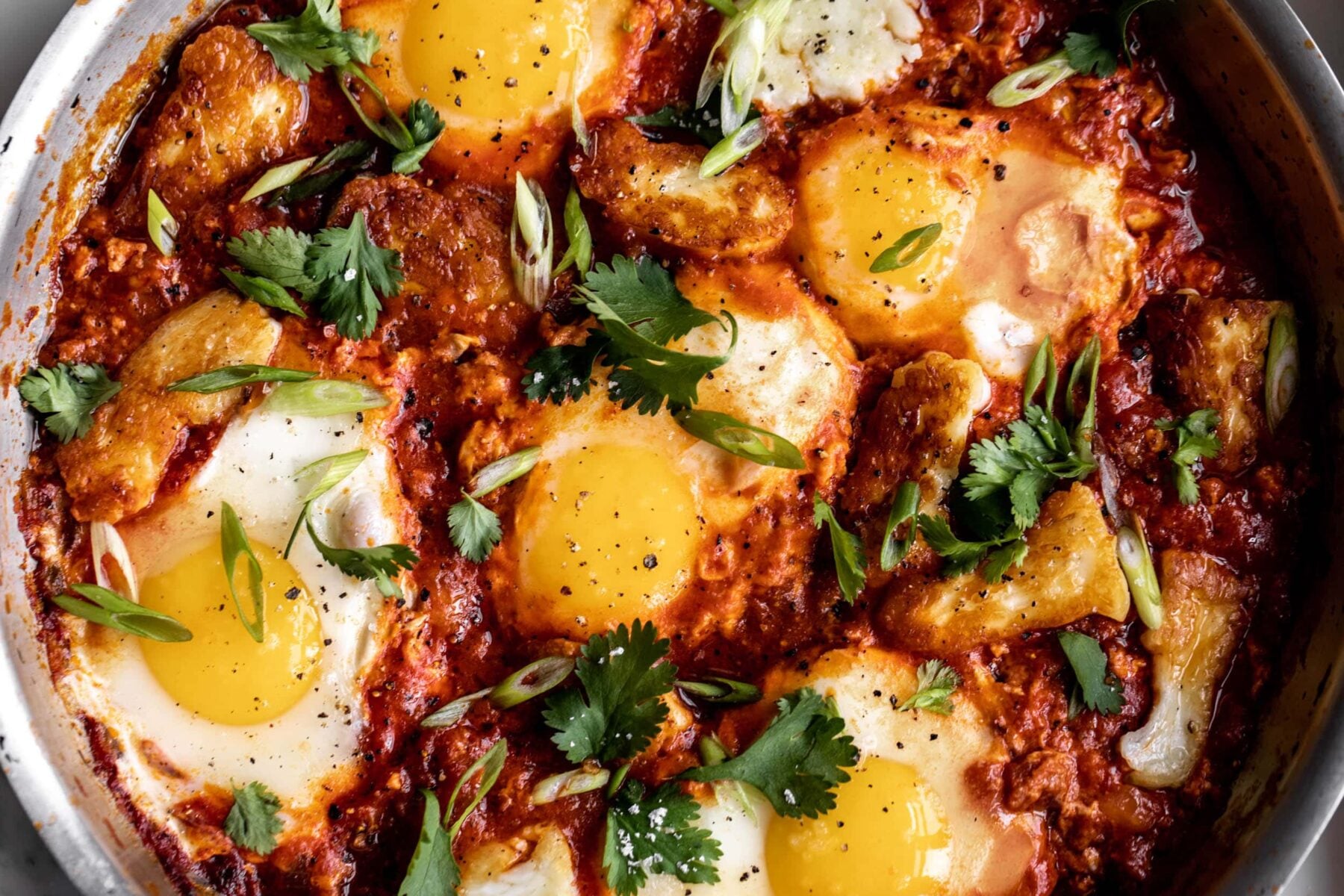 shakshuka recipe with fried halloumi spicy baked eggs in tomato sauce.