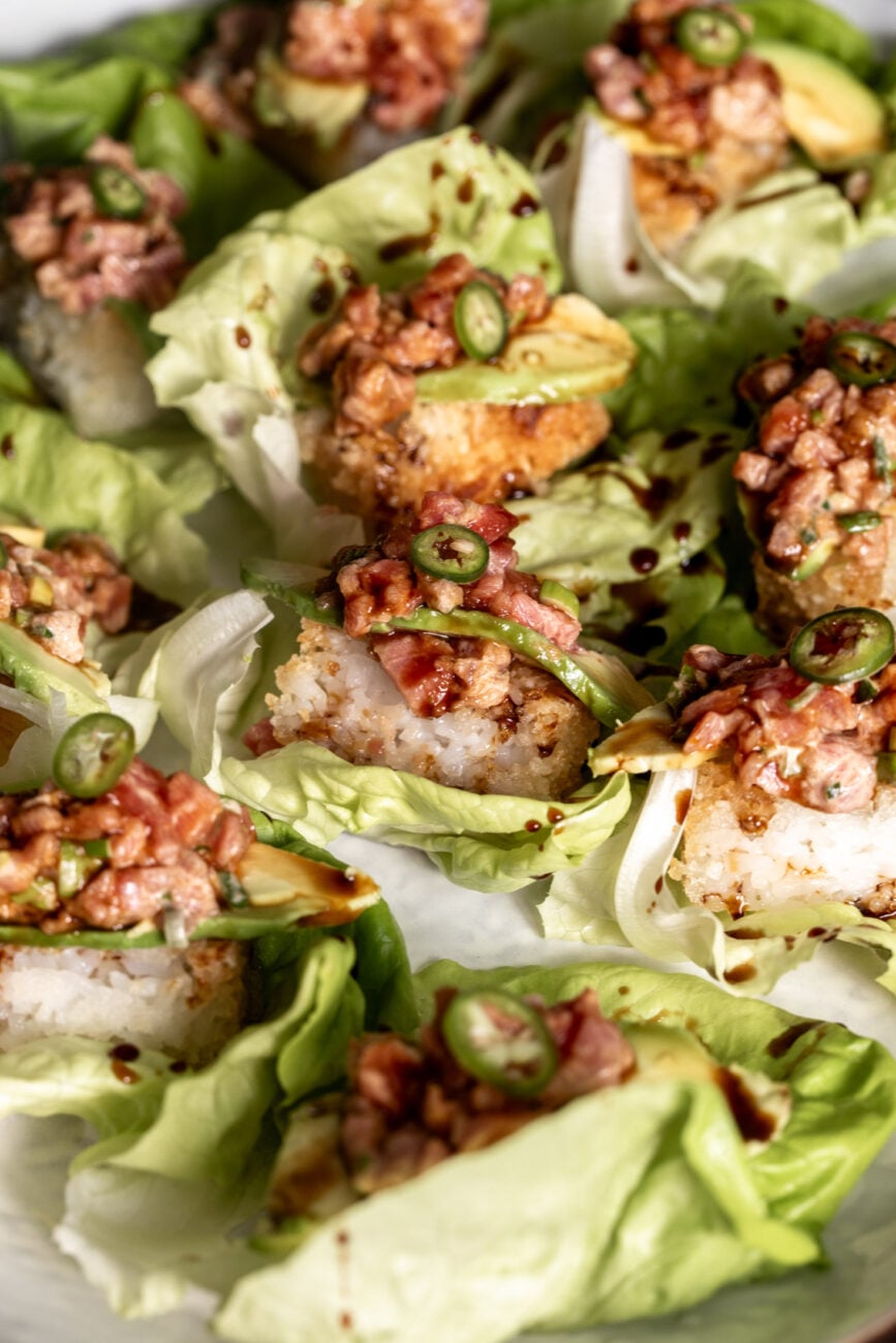 Crispy Rice Topped with Spicy Tuna avocado and jalapeño drizzled with eel sauce in butter lettuce cups.