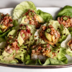 Crispy Rice Topped with Spicy Tuna avocado and jalapeño drizzled with eel sauce in butter lettuce cups.