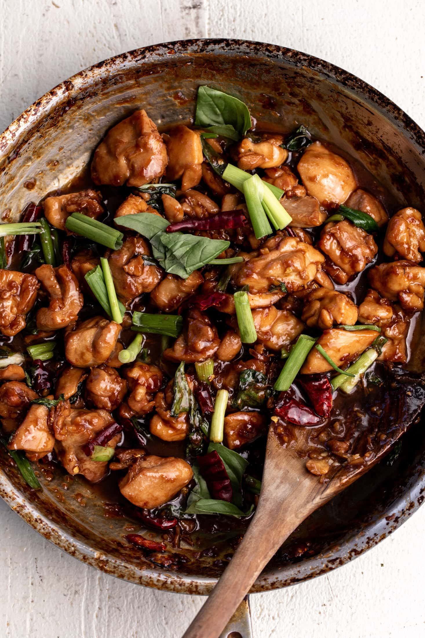 Skillet of authentic Taiwanese Three Cup Chicken with basil and garlic.