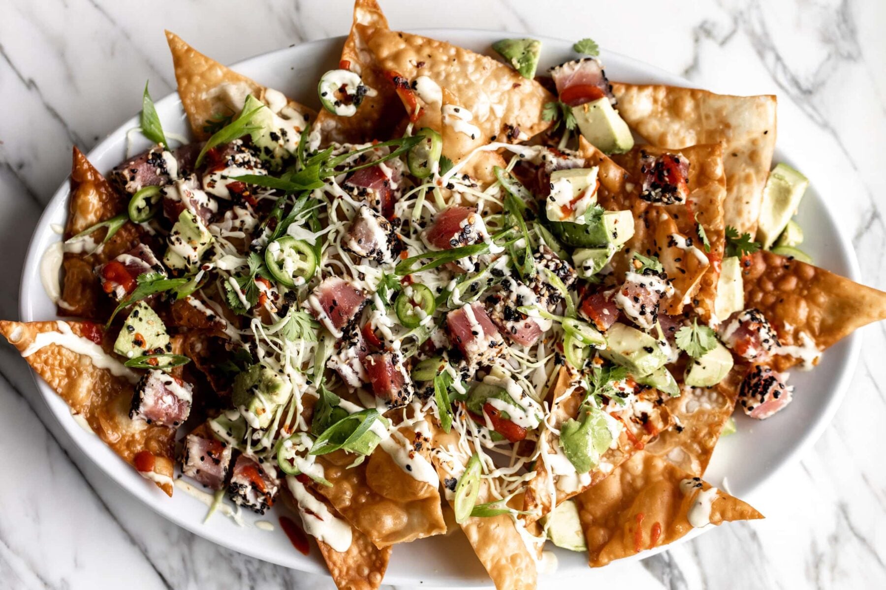 pieces of ahi tuna over fried wonton chips with wasabi mayonnaise, sriracha drizzle and avocado.