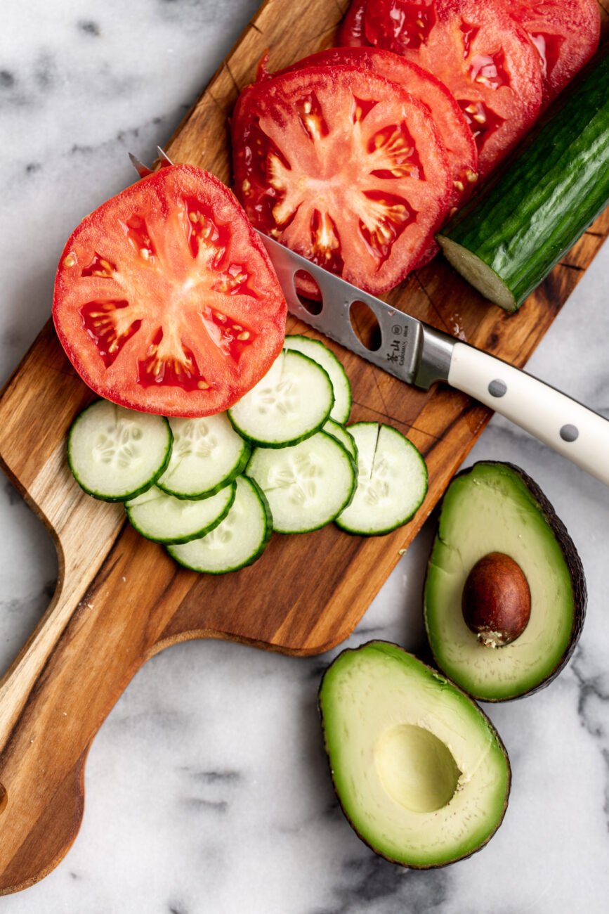 sliced cucumber and tomato with halved avocado.