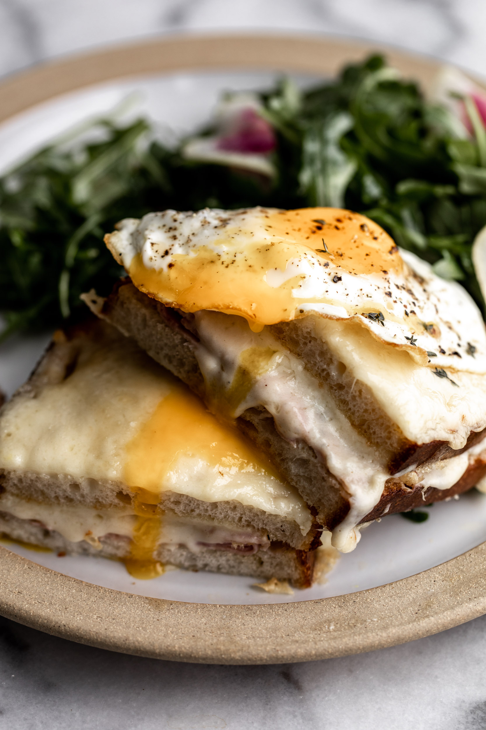 Croque Madame topped with mornay sauce and shredded gruyere cheese