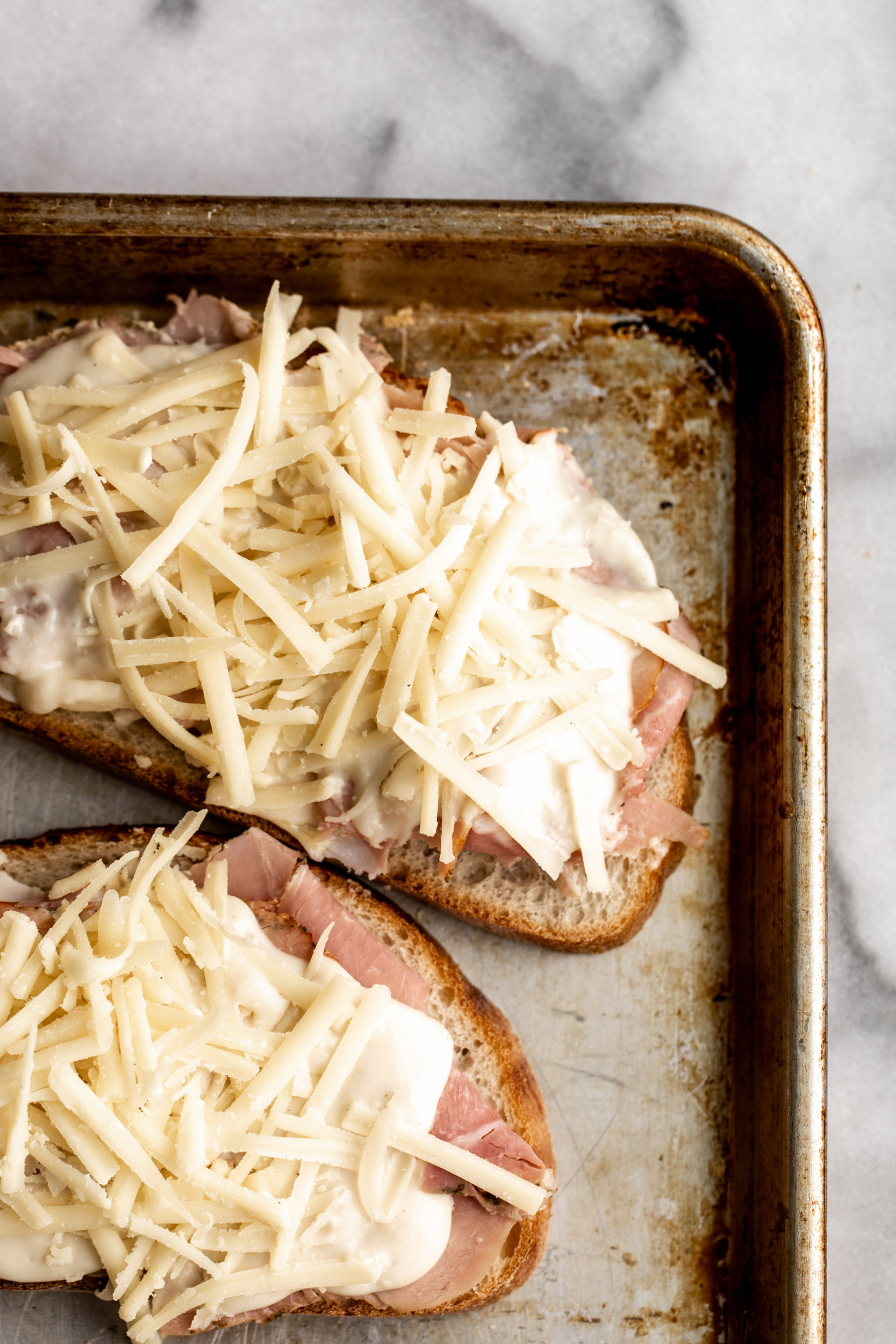 Croque Madame topped with mornay sauce and shredded gruyere cheese