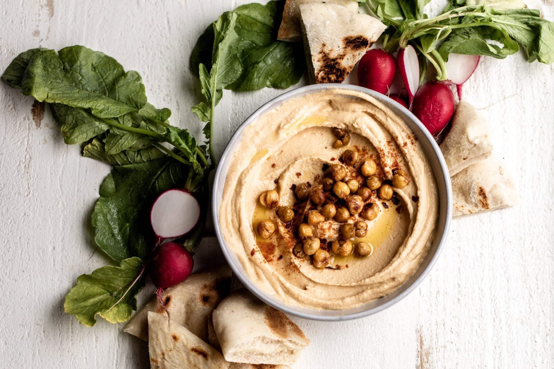 spicy hummus with crispy chickpeas served with pita and radish.