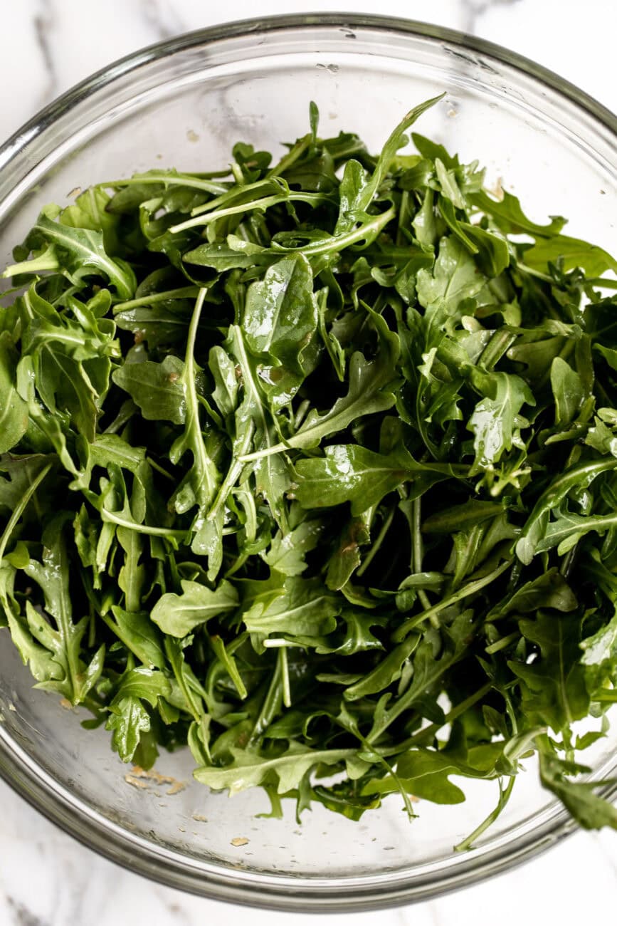 wild arugula with soy ginger dressing in bowl.