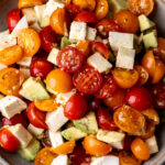 tomato avocado and mozzarella simple salad in stone bowl.