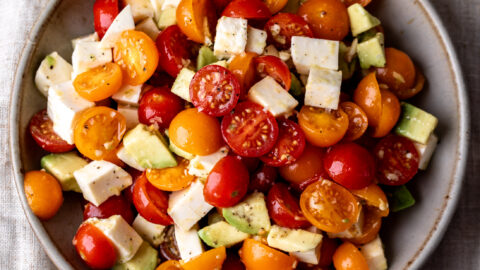 tomato avocado and mozzarella simple salad in stone bowl.