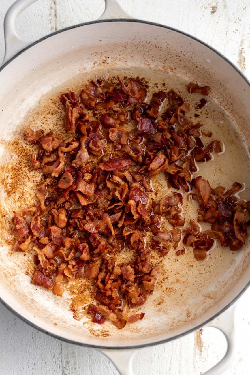 cooked sliced bacon in pot with rendered bacon fat.