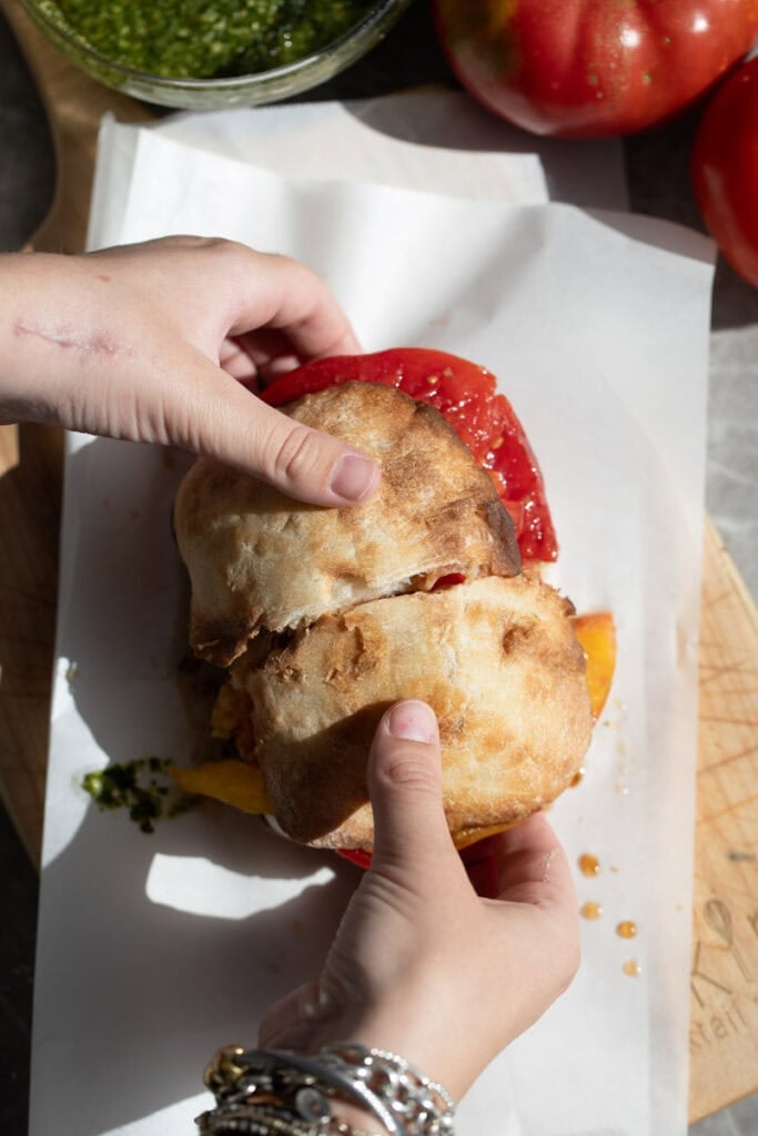 assembled caprese sandwich on parchment paper.