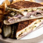 cuban sandwich with roast pork, ham, swiss cheese and pickles.