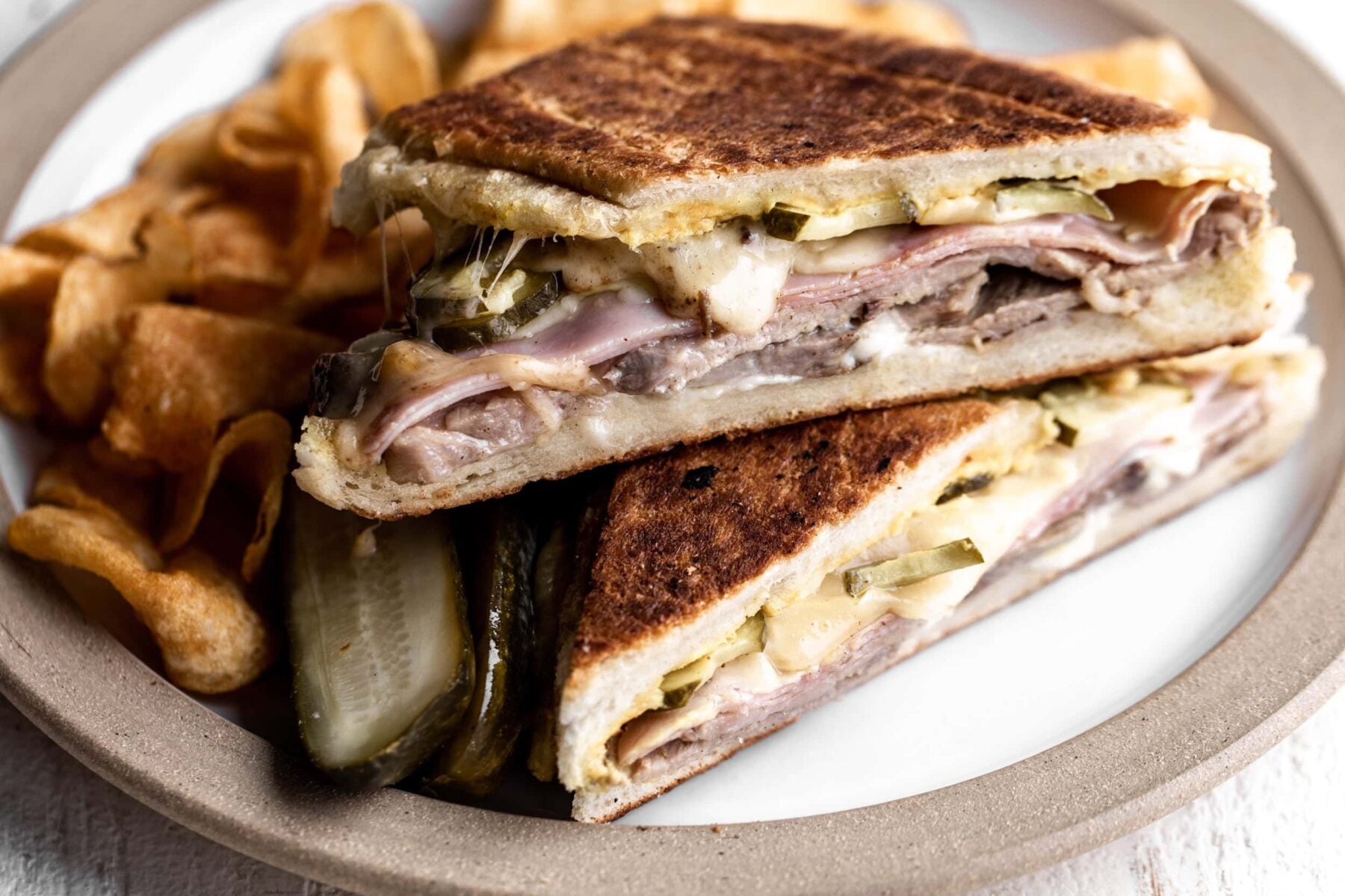 cuban sandwich with roast pork, ham, swiss cheese and pickles.