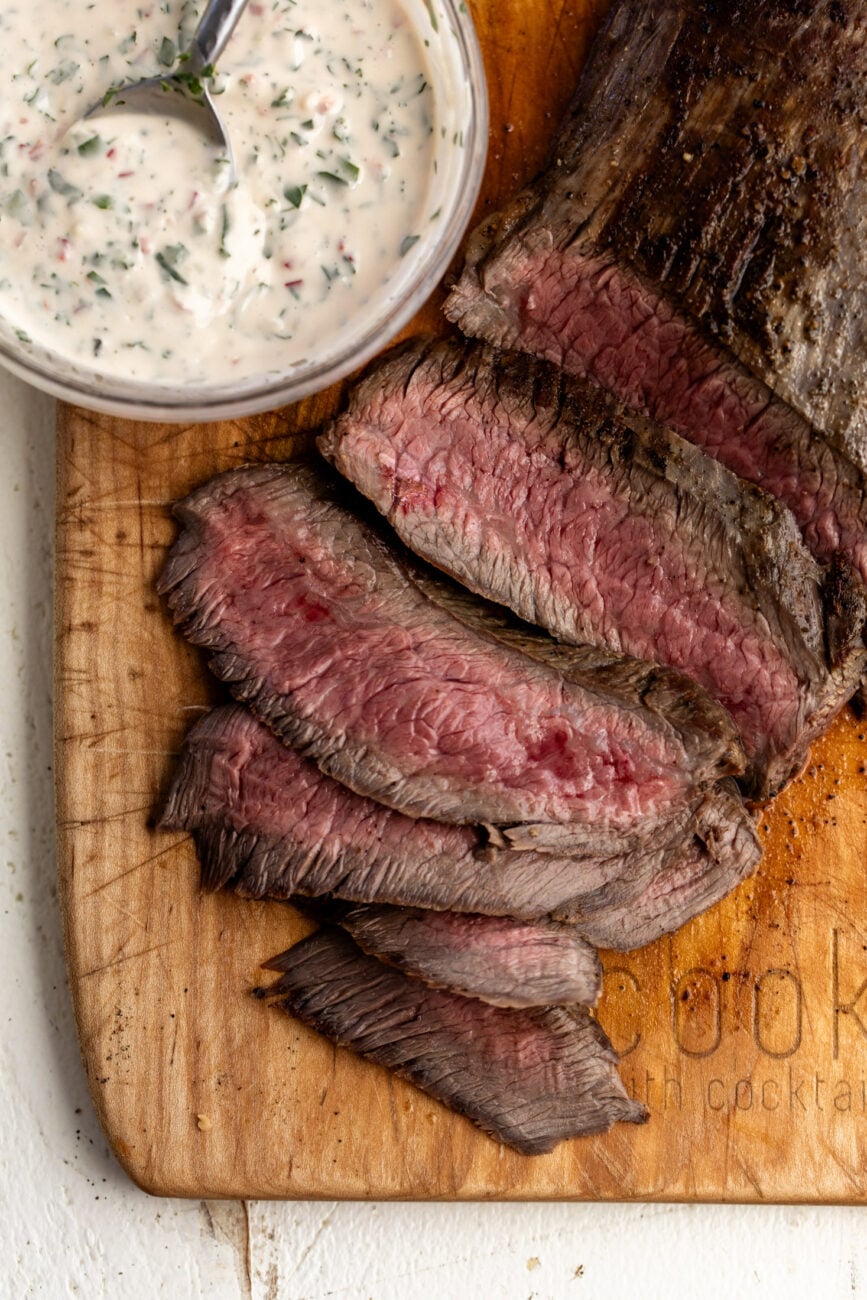 seared flank steak sliced on cutting board.
