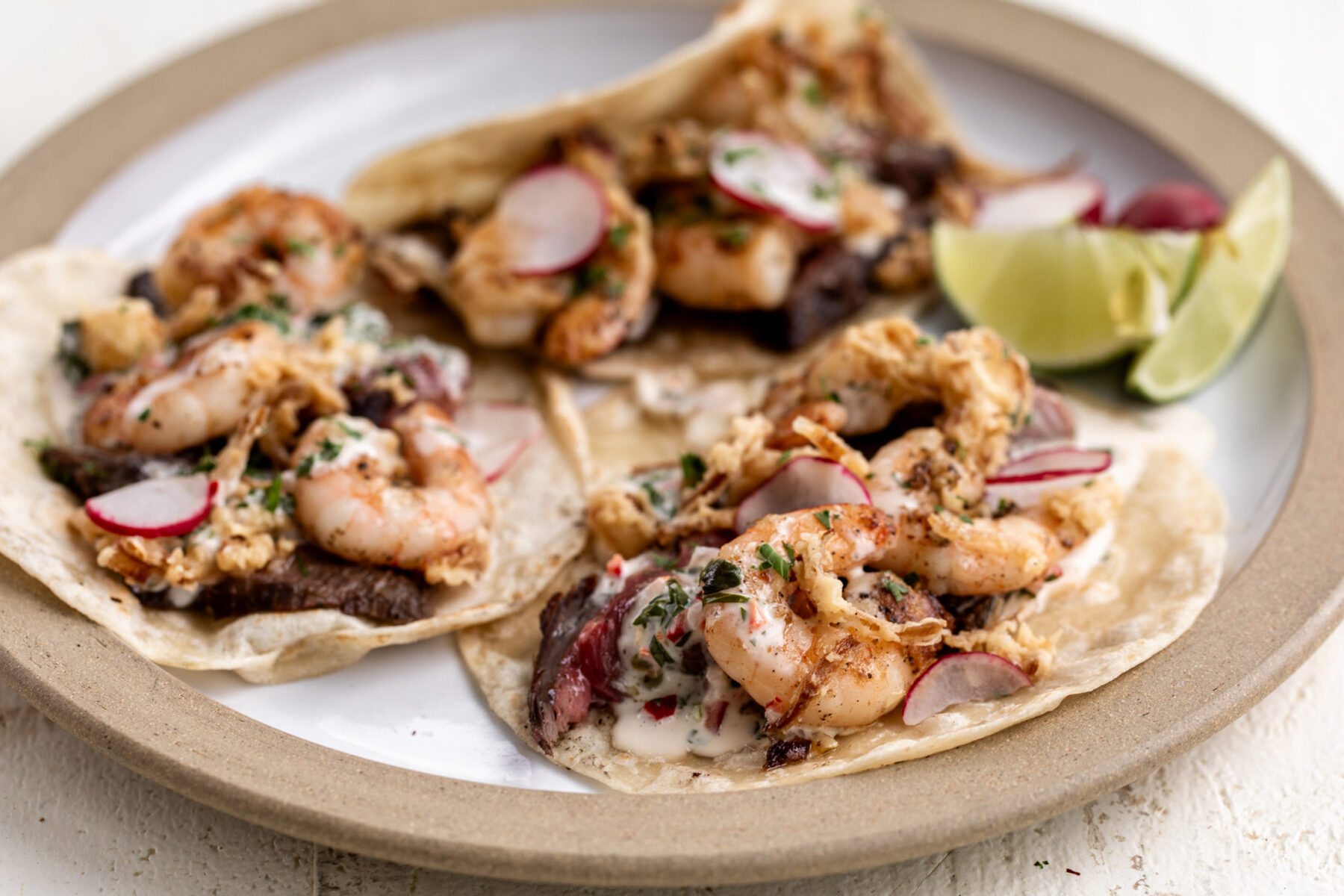 surf and turf tacos with crispy onions and chimichurri aioli.
