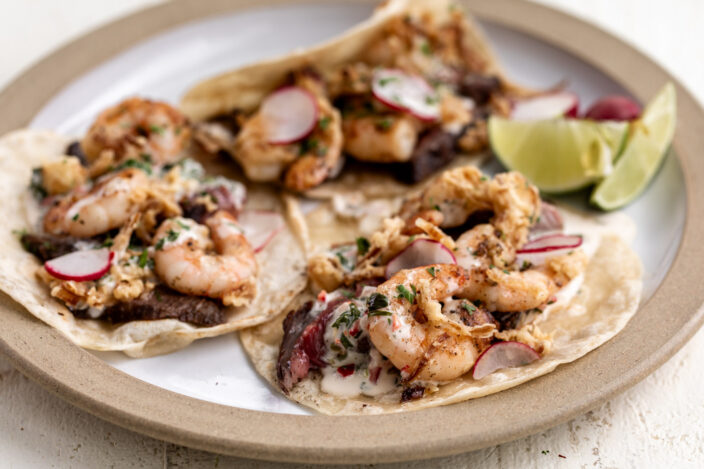 surf and turf tacos with crispy onions and chimichurri aioli.