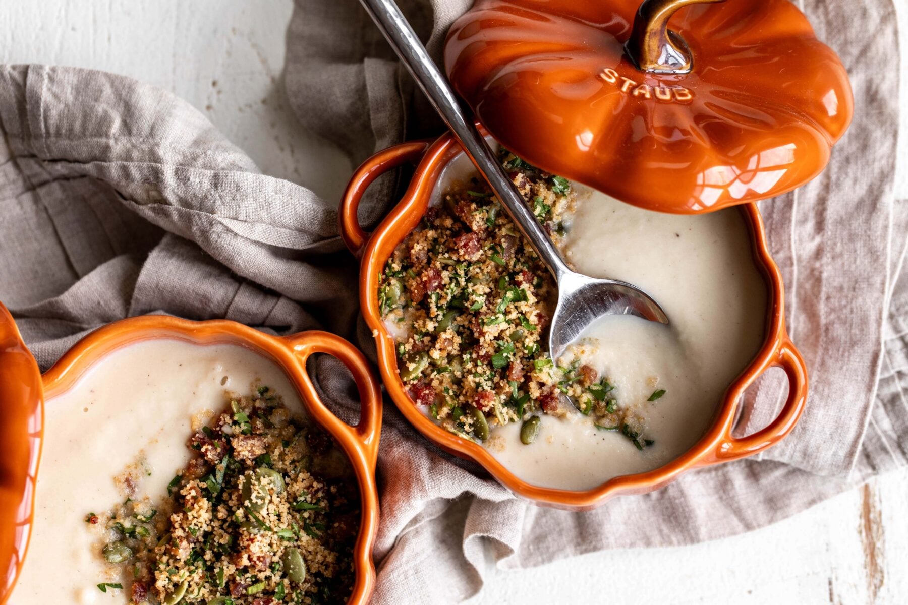 Roasted Garlic Cauliflower Soup with Pancetta and Toasted Breadcrumbs in pumpkin staub cocotte.