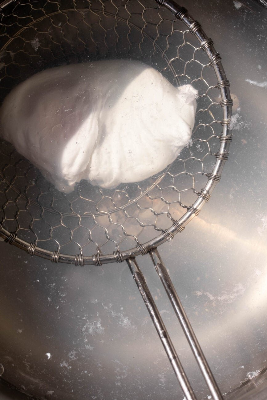 poached egg in water with strainer.