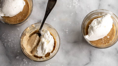 Salted Butterscotch Pots de Crème in small glass jars with whipped cream