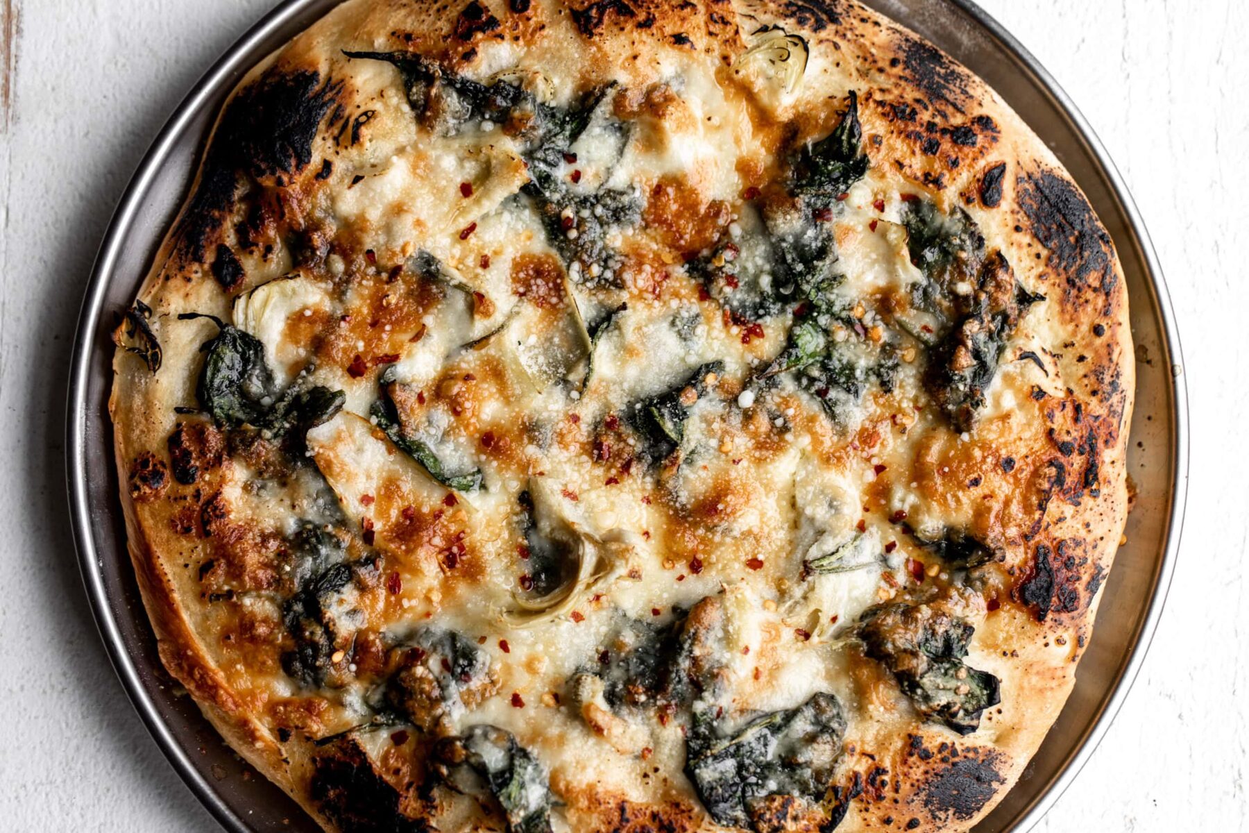 Spinach artichoke pizza close up.
