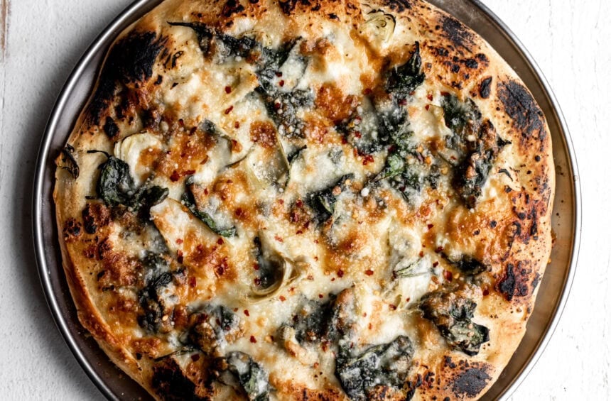 Spinach artichoke pizza close up.