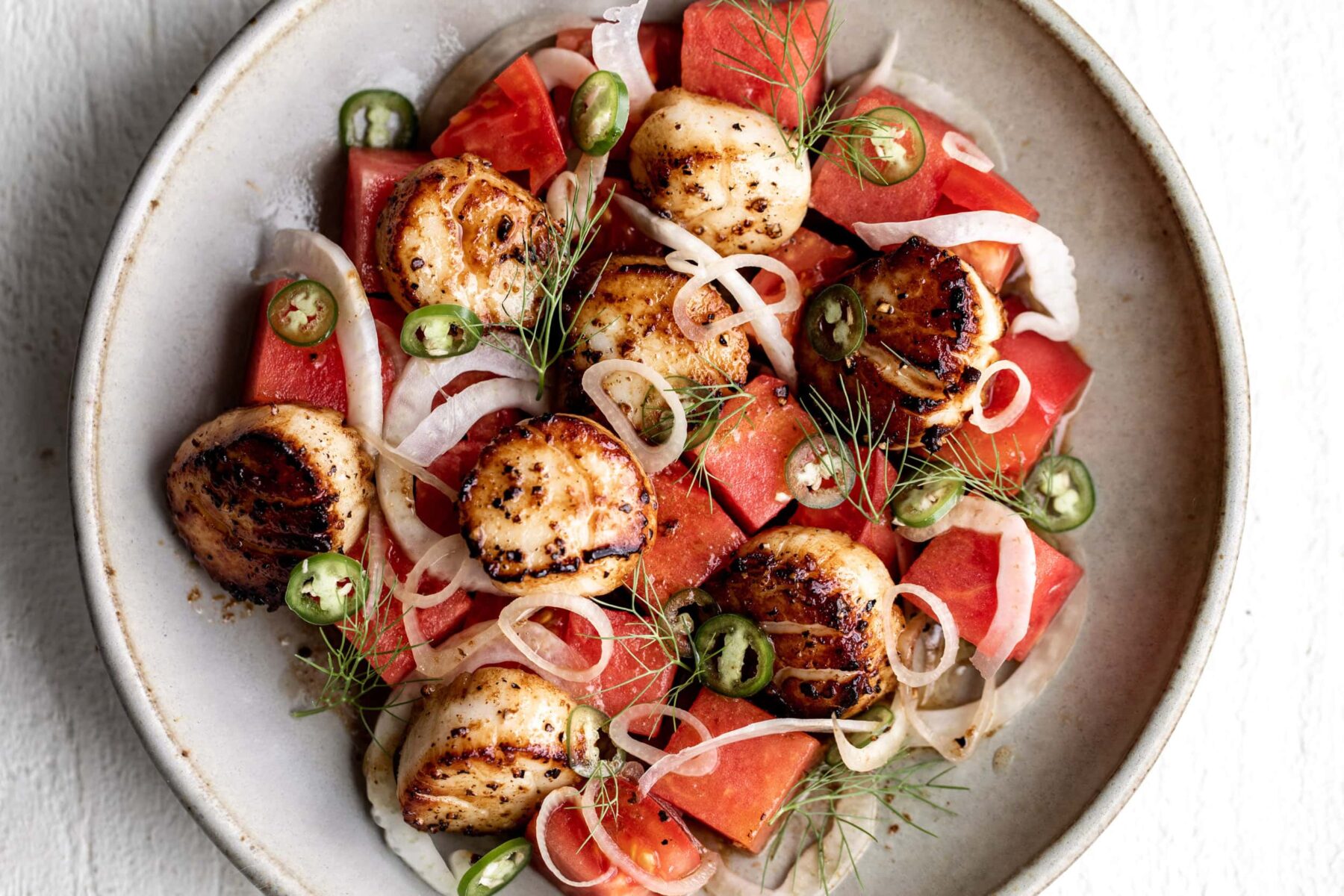 scallops seared in golden-brown butter sauce with fresh sweet watermelon and spicy Serrano pepper.