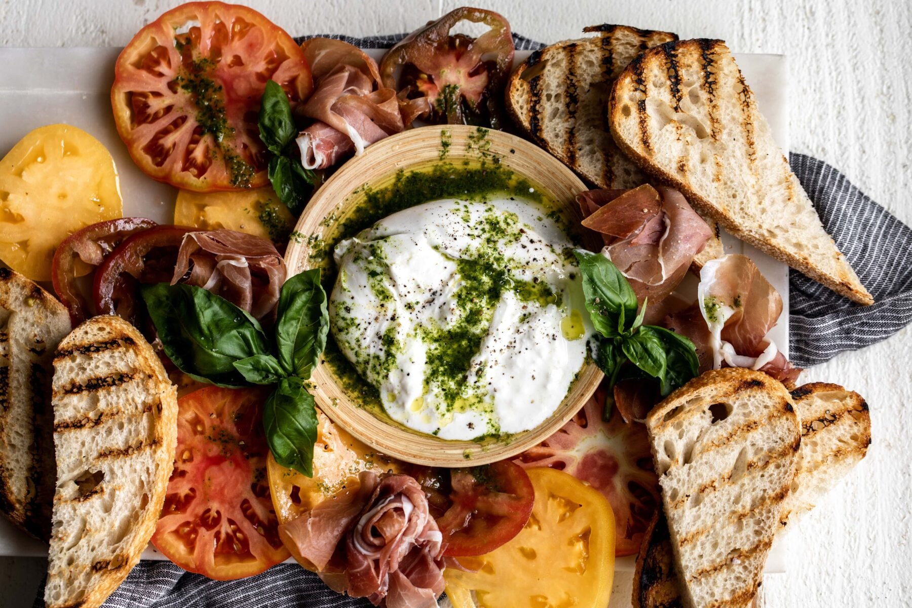 Heirloom tomato, prosciutto and burrata with garlic basil oil. 