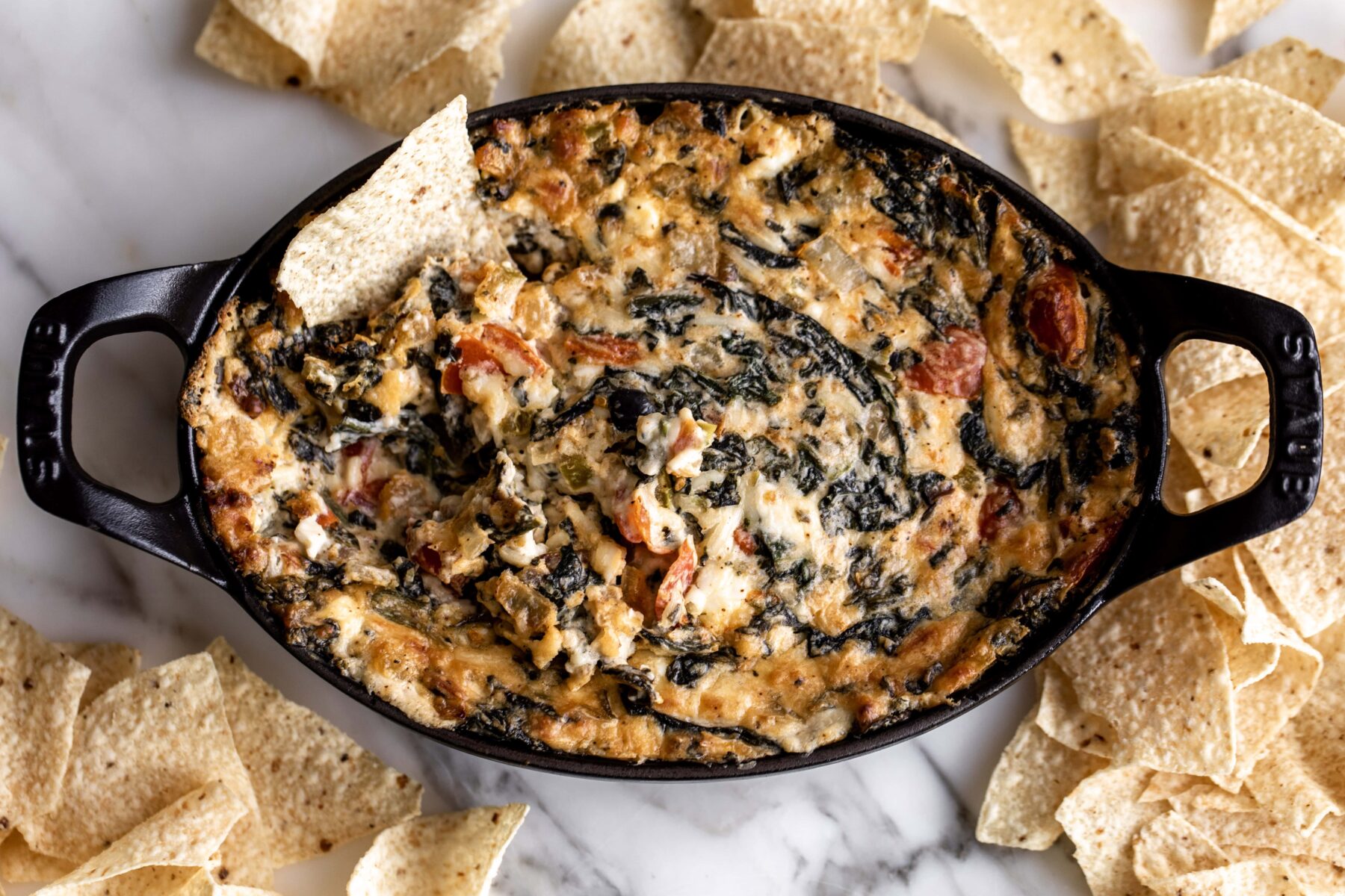 Hot and spicy creamy spinach dip with tortilla chip.