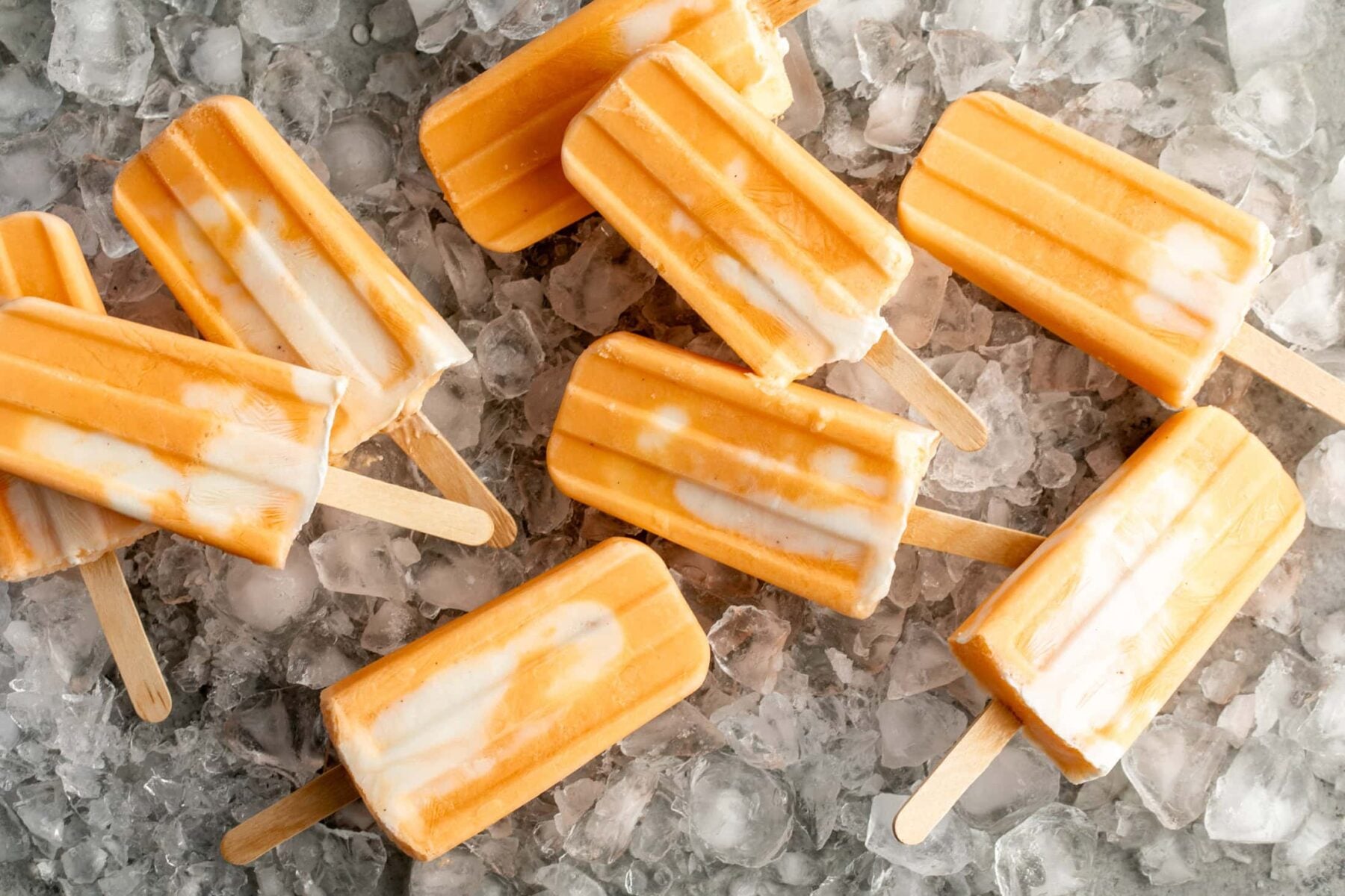 orange creamsicle ice pops on bed of ice.