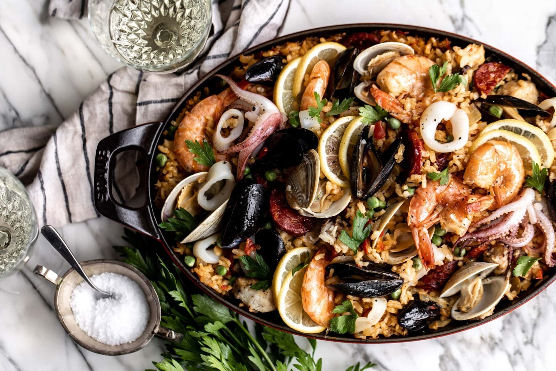 seafood and chorizo spanish paella recipe filled with shrimp, squid, mussels, clams and fish.
