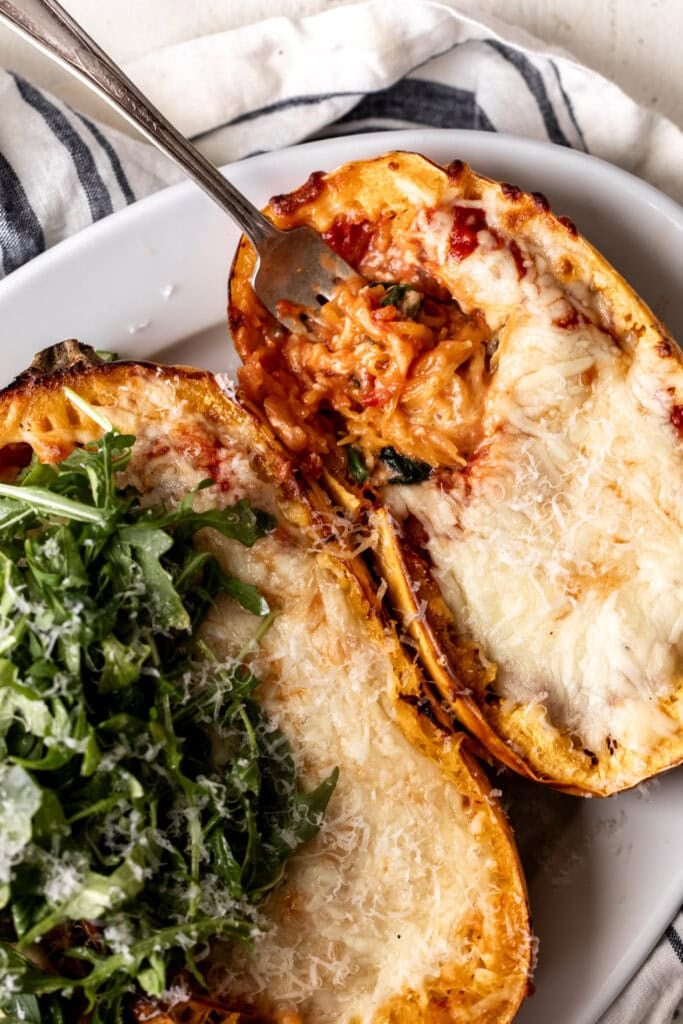spaghetti squash lasagna boat topped with arugula and cheese.