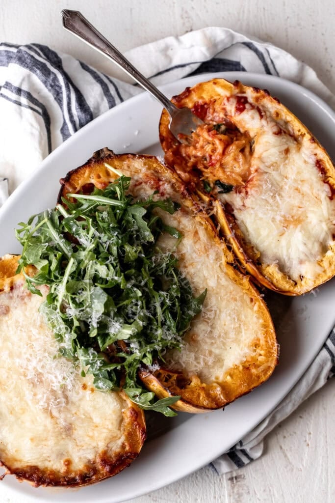 spaghetti squash lasagna boats topped with arugula salad.