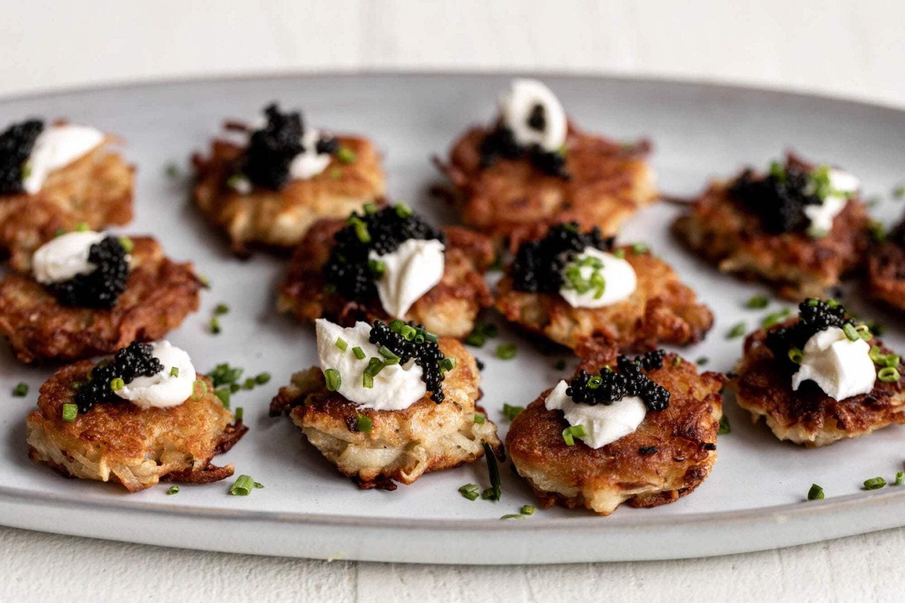 Fancy mini latkes topped with creme fraiche, caviar and chives.