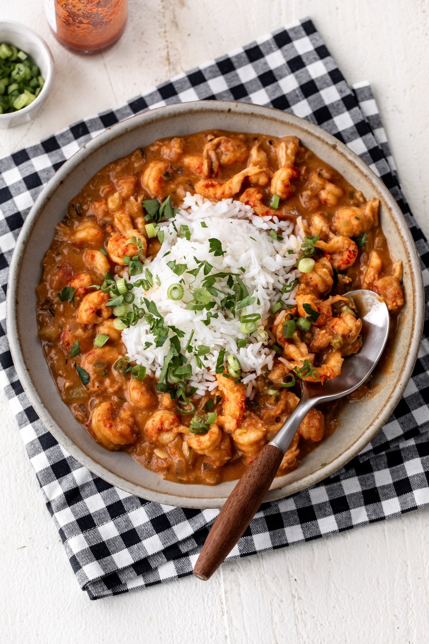 cajun crawfish étouffée with rice topped with green onion and parsley.