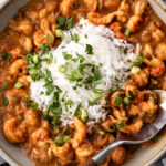 spoon of Crawfish Etouffée with rice and green onions.
