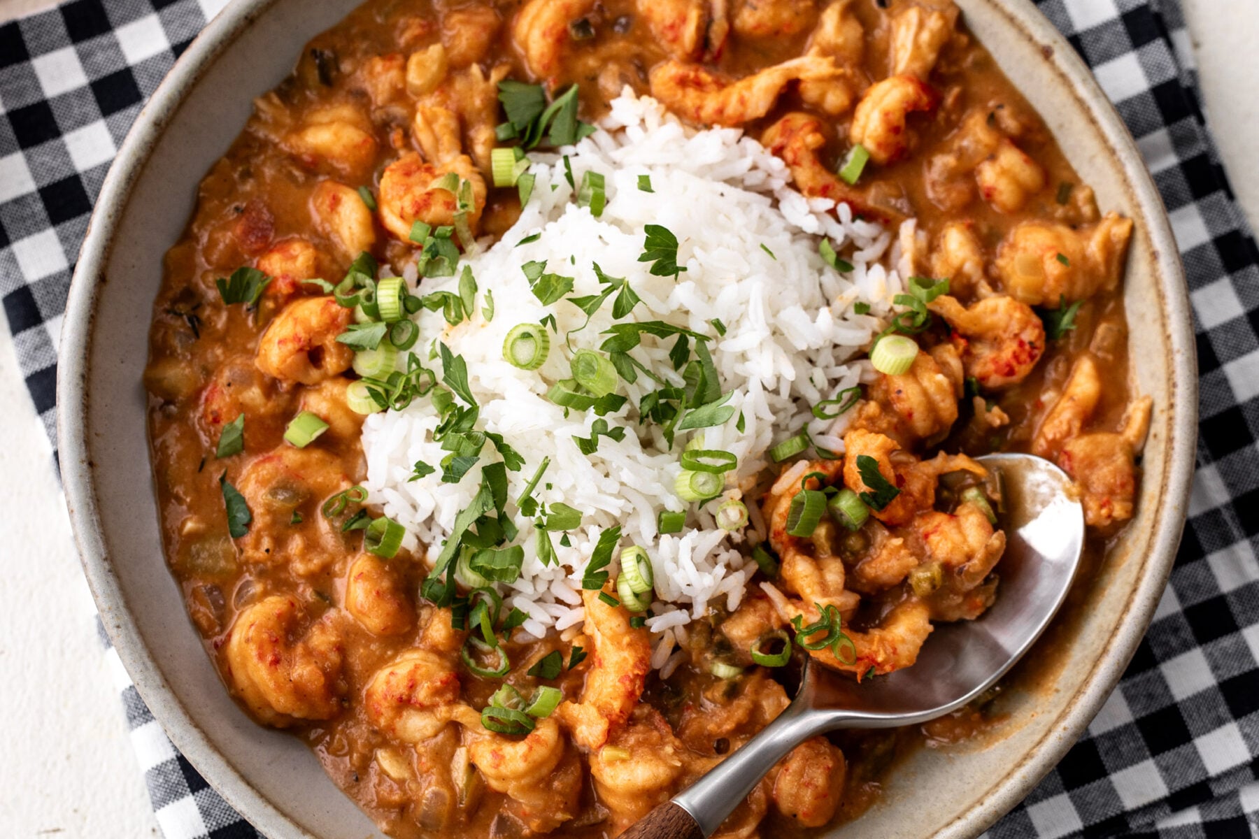 spoon of Crawfish Etouffée with rice and green onions.