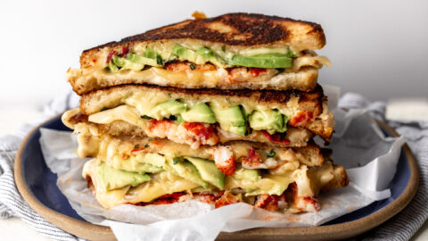 lobster avocado grilled cheese stacked on plate