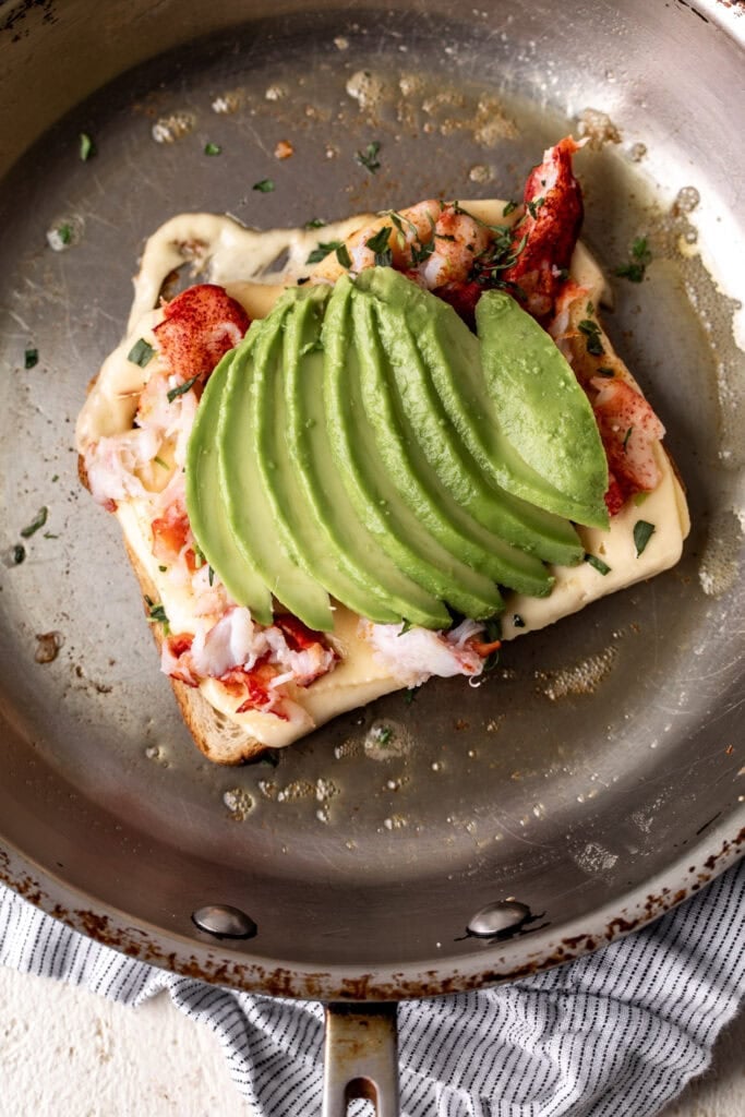 lobster grilled cheese with avocado assembled in pan.
