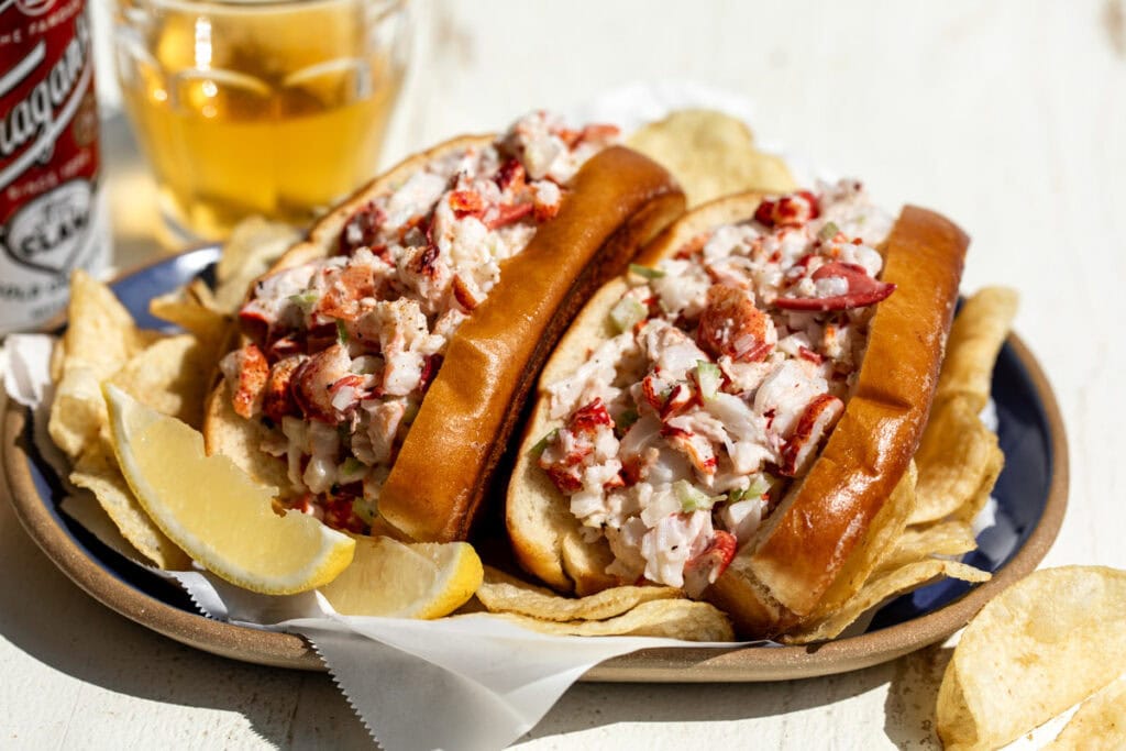 new england style lobster rolls in brioche buns with chips.