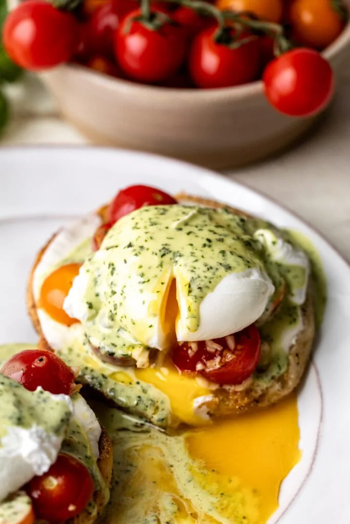 caprese eggs benedict with marinated cherry tomatoes, mozzarella and basil hollandaise