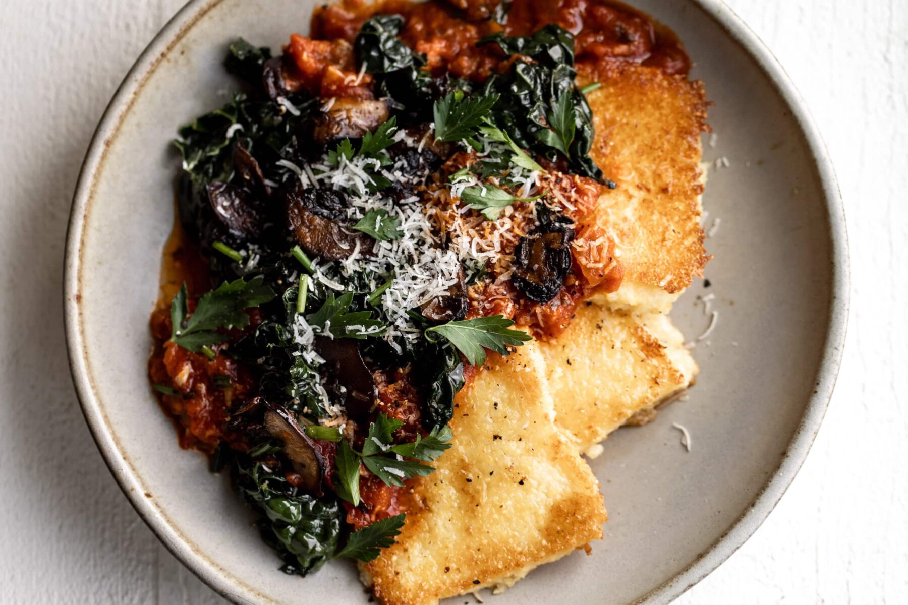 Crispy Polenta with Spicy Tomato Sauce, Sautéed Kale & Mushrooms.
