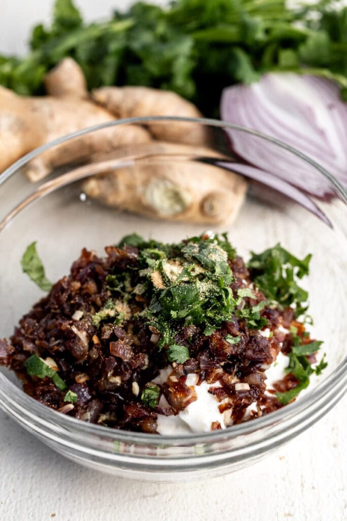 pho inspired caramelized onion dip ingredients mixed in glass bowl.