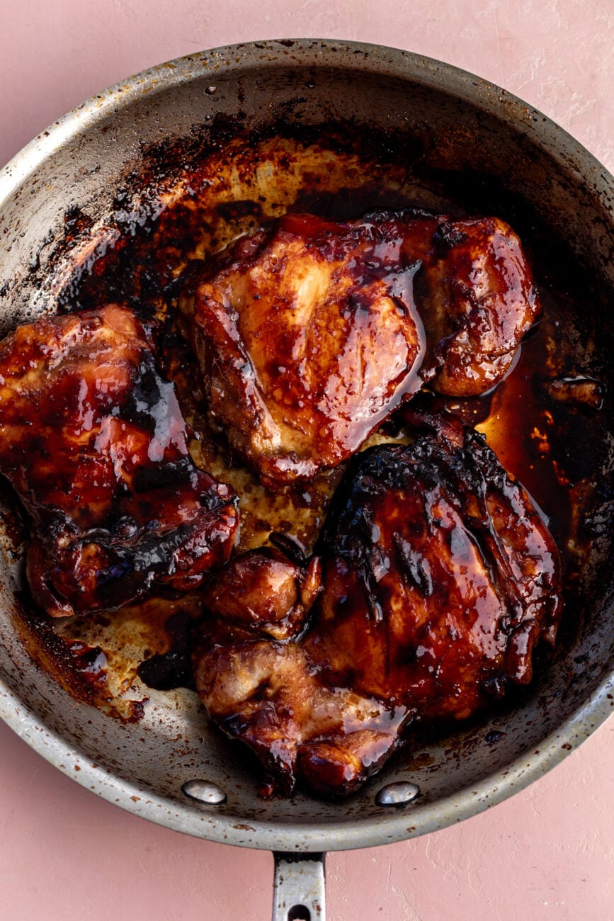 cooked teriyaki glazed chicken thighs cooked in pan.