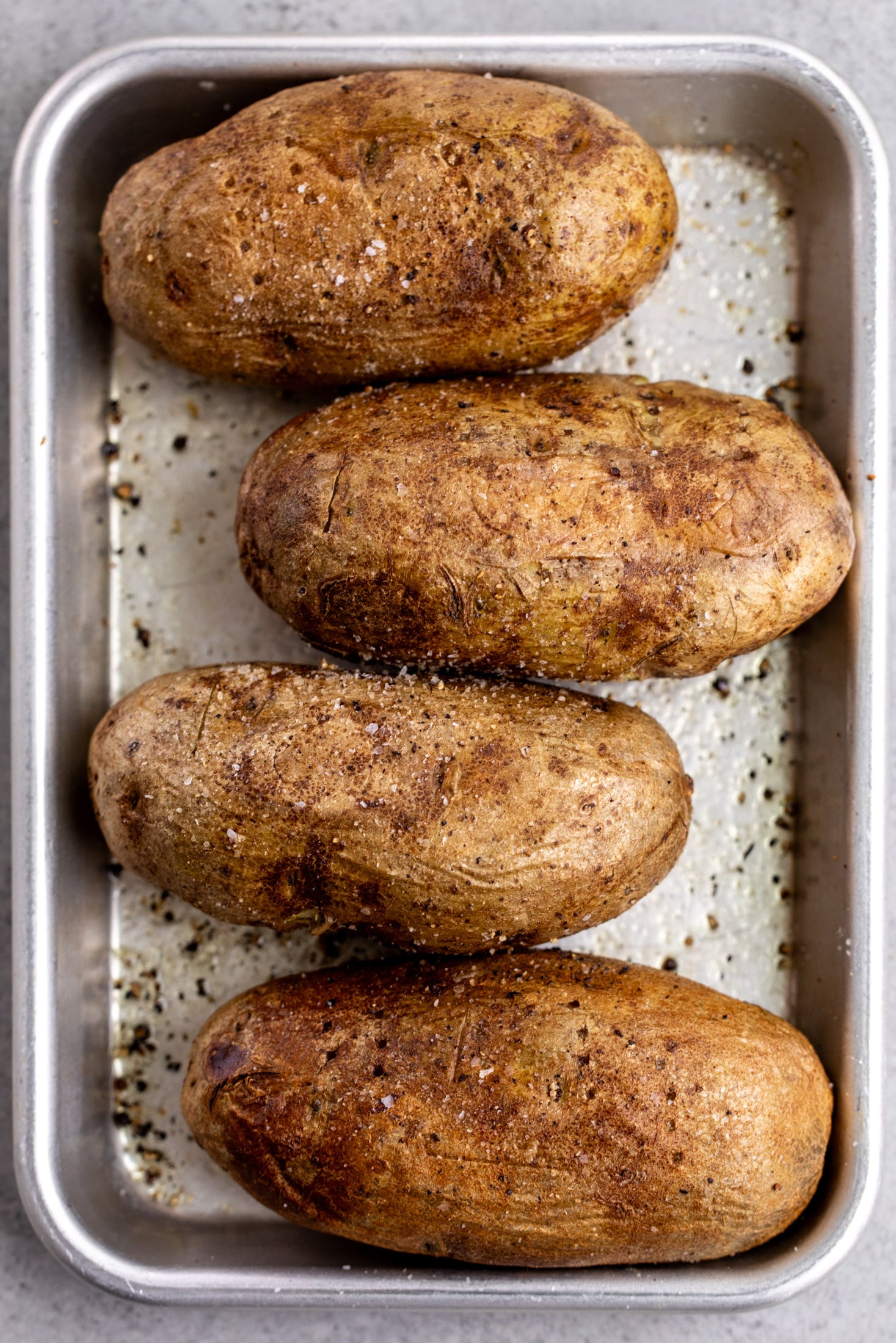baked jacket potatoes on a baking sheet.