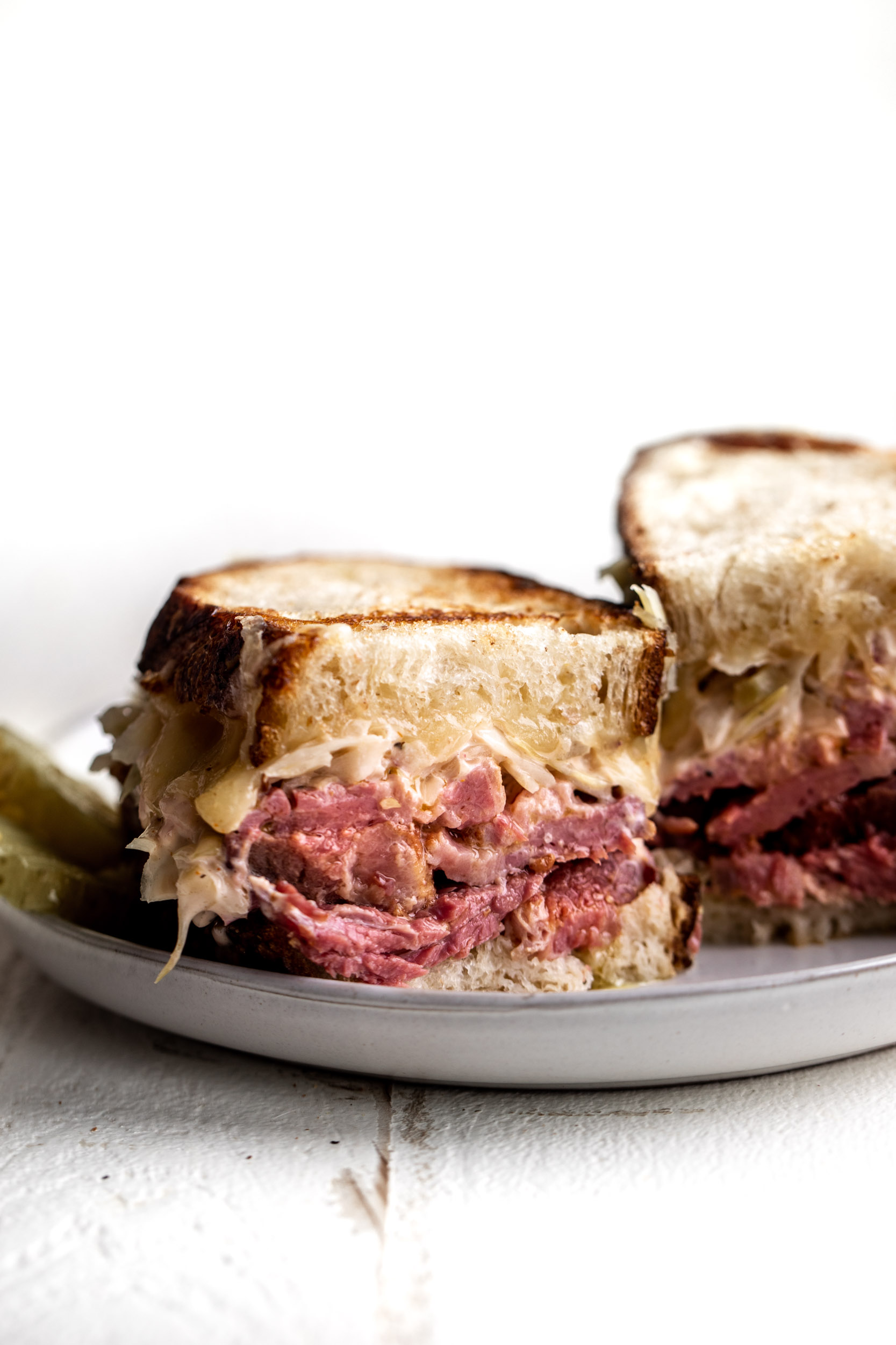 Classic Reuben sandwich with slices of corned beef on sliced dark rye bread with sliced Swiss cheese and sauerkraut