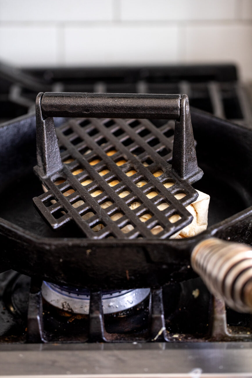 pressed breakfast burrito in cast iron pan.