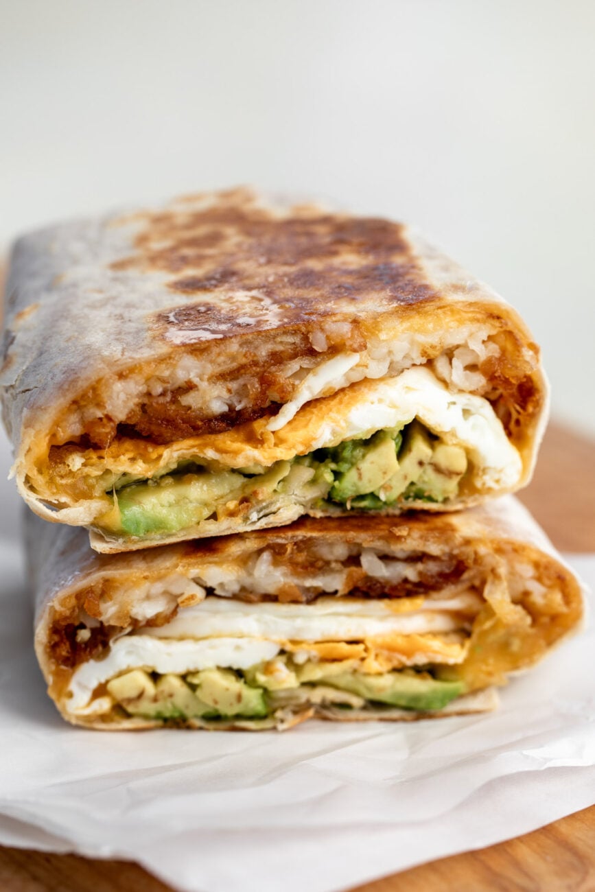 halved vegetarian breakfast burrito with avocado.